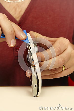 Technician disassembling smartphone with zoom camera lens to fix it Stock Photo