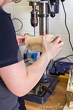 Technician drilling hole into prosthetic limb Stock Photo
