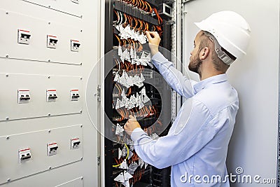 Technician engineer in datacenter. Network technician connecting fiber optic at server room. Stock Photo
