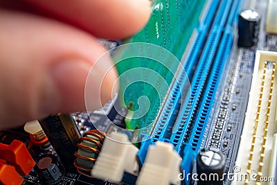 Technician engineer inserts the RAM into the motherboard slot. The concept of high technology and repair microchip Stock Photo
