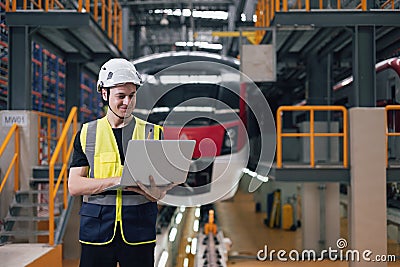 Technician Engineer maintenance service electric train with laptop computer in train repair depot. Train designer in factory Stock Photo