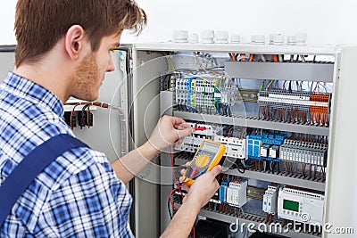 Technician examining fusebox with insulation resistance tester Stock Photo