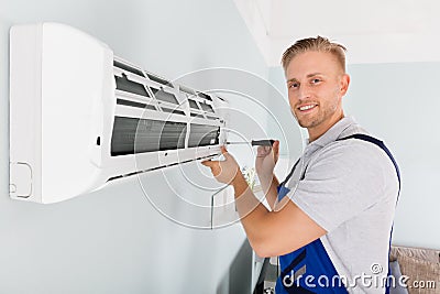 Technician Fixing Air Conditioner Stock Photo