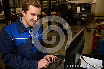 A technician, garage mechanic conducting diagnostic check of a car during regular warranty maintenance in auto service Stock Photo