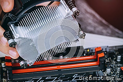 Technician hands installing CPU cooler fan on a computer pc motherboard Bitcoin mining cryptocurrency with GPU rigs. Stock Photo