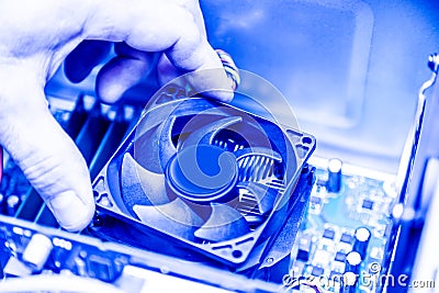 Technician hands installing CPU cooler fan on a computer pc motherboard. Toned image Stock Photo