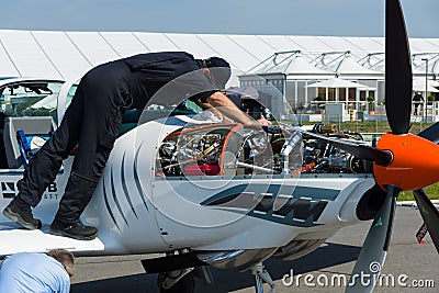 Technician inspects turboprop engine two-seater training and aerobatic low-wing aircraft Grob G 120TP. Editorial Stock Photo