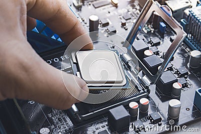 Technician install CPU processor chip in socket Stock Photo