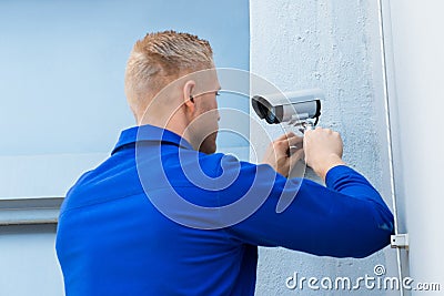 Technician Installing Camera In Corner Stock Photo