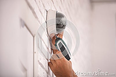 Technician installing CCTV camera on wall Stock Photo