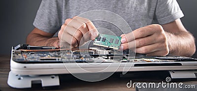 Technician installing random access memory on laptop computer Stock Photo