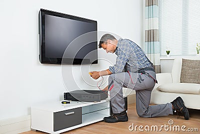 Technician Installing TV Set Top Box At Home Stock Photo