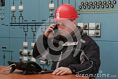 Technician make mobile phone call in the power plant control center Stock Photo