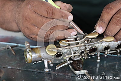 The technician man is repairing the vintage style saxophone instrument. Stock Photo