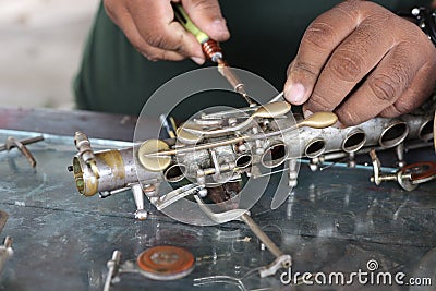 The technician man is repairing the vintage style saxophone instrument. Stock Photo