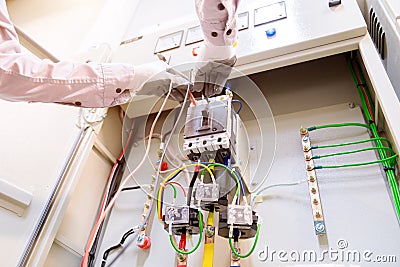 Technician is measuring voltage or current by voltmeter in control panel of power plan Stock Photo