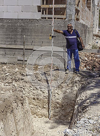 Technician places a stadia for reading through a theodolite Stock Photo