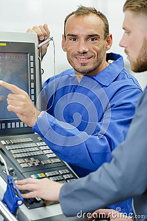 technician pointing to screen computerised control panel Stock Photo