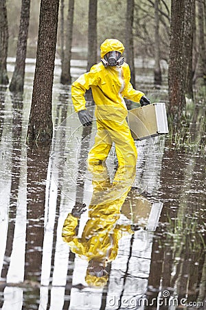 Technician in professional uniform with silver suitcase in contaminated floods area Stock Photo