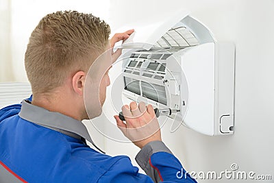 Technician repairing air conditioner Stock Photo