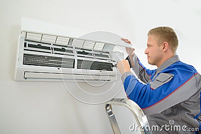 Technician repairing air conditioner Stock Photo