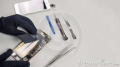 Technician repairing broken smartphone on desk Stock Photo