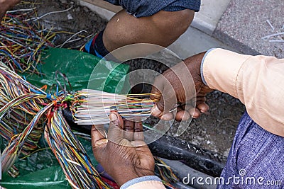 Technician repairing an underground telephone line multicolored wires Stock Photo