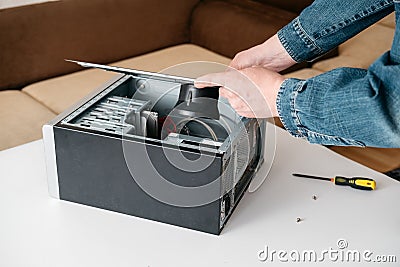 Technician take off part of desktop pc system unit, disassemble computer for repair in service workshop Stock Photo