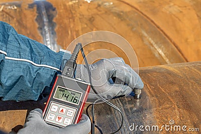 Technician is testing to pipe thickness with ultrasonic test method. Ultrasonic thickness measurement (UTM) Stock Photo