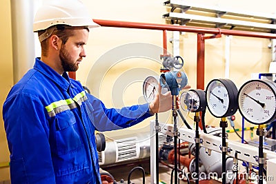 Technician worker on oil and gas refinery checks pressure manometers. Stock Photo