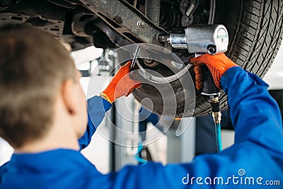 Technician with a wrench repair car suspension Stock Photo