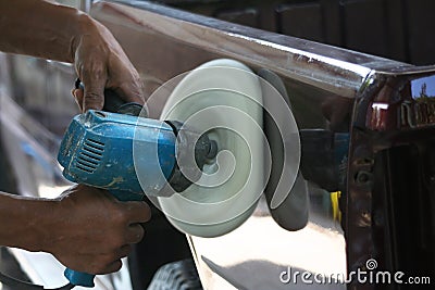 Automotive paint technician using grinder machine with wax on side of pickup , A part of the procedure to make a new color car Stock Photo