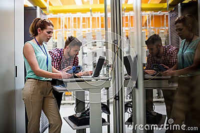 Technicians using laptop while analyzing server Stock Photo