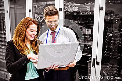 Technicians using laptop while analyzing server Stock Photo
