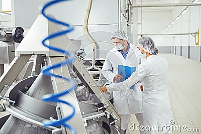 Technologists inspector in masks at food factory. Stock Photo