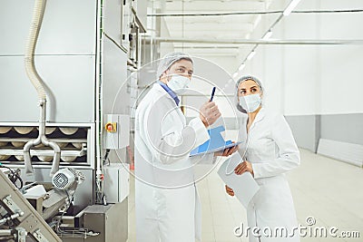 Technologists inspector in masks at food factory. Stock Photo