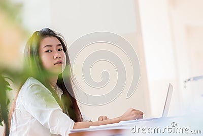 Technology Learning concept: Asian Young woman student learning and check timetable for projected in laptop computer at busy table Stock Photo