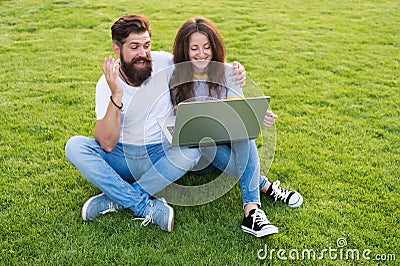 Technology in leisure. Couple in love use laptop on green grass. New technology. Technology for communication. Computer Stock Photo