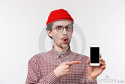 Technology and people concept. Close-up portrait fascinated and impressed good-looking young man in red beanie and Stock Photo