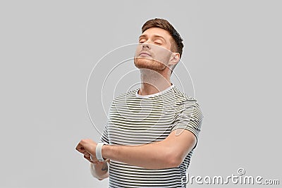 Calm young man with smart watch meditating Stock Photo