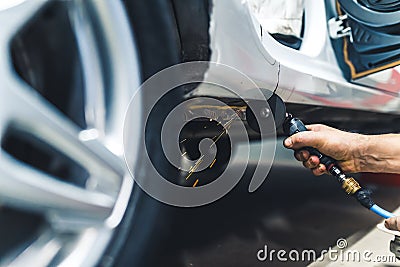 Technology used at mechanic& x27;s. Indoor low-angle view of working angle grinder cutting into metal chassis. Blurred Stock Photo