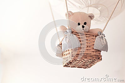 Teddy bear in a aerostatic balloon toy hanging from the ceiling. Stock Photo