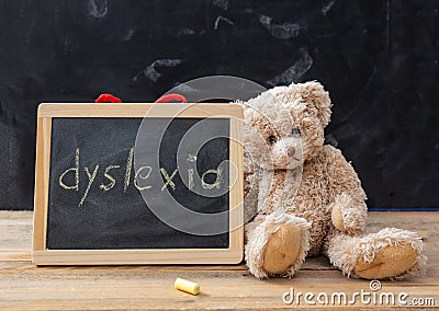 Teddy bear and a blackboard. Dyslexia text drawing on the blackboard Stock Photo