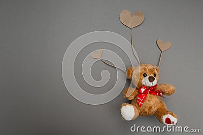 Teddy bear flies on paper hearts as on the balls Stock Photo