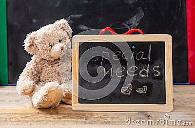 Teddy bear hiding behind a blackboard. Special needs text drawing on the blackboard Stock Photo