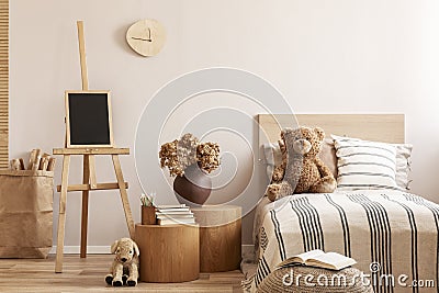 Teddy bear on single wooden bed in natural kid`s bedroom Stock Photo