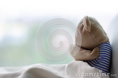 Teddy bear sobbing on bed in the sadly day Stock Photo