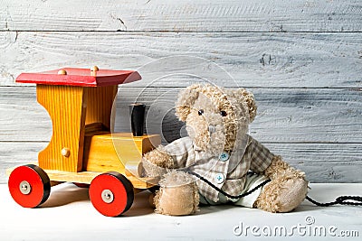 Teddy bear and toy wooden train, wooden background Stock Photo