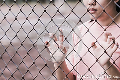 Teen behind the cage or woman jailed Stock Photo