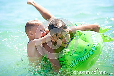 Teen boy and little boy play in water Stock Photo